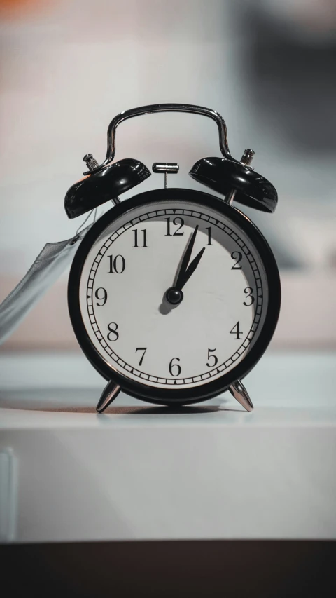 a black clock is on a white ledge