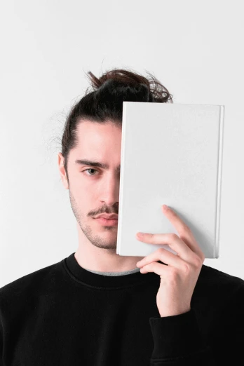a person holding a book up to his face