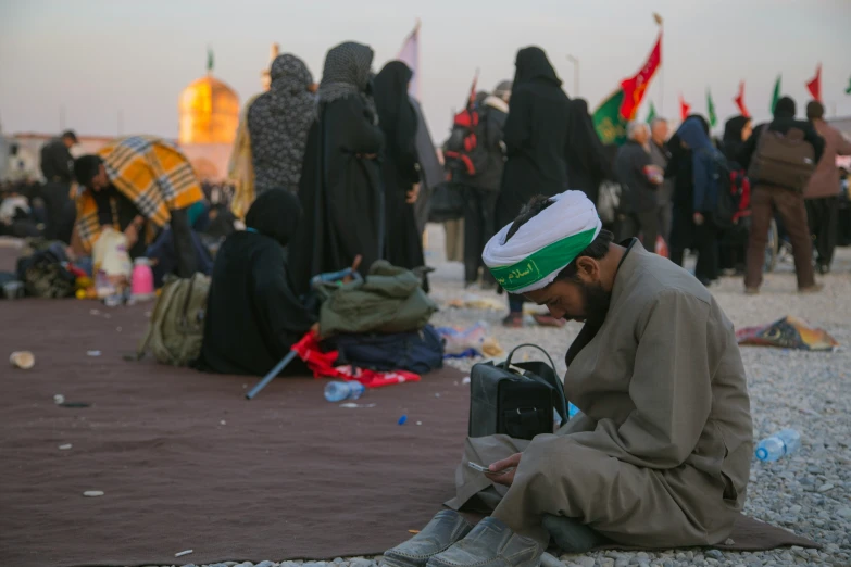 a man sitting down with a camera in front of other people