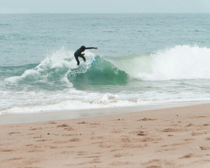 a surfer balances on their board on the waves