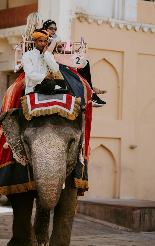 two people ride on the back of an elephant