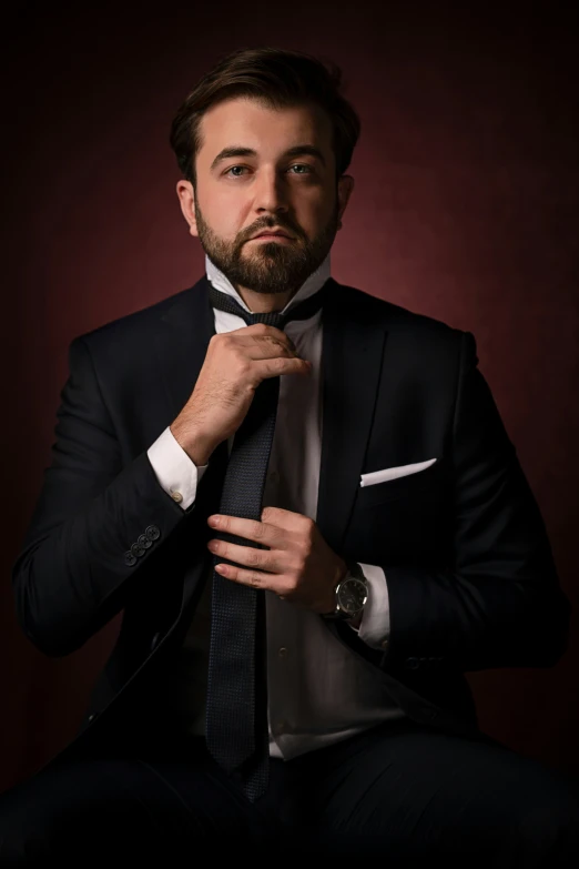 a man wearing a suit and tie and looking at the camera