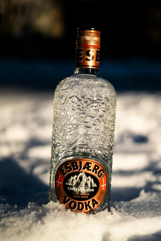 there is a bottle of vodka sitting in the snow