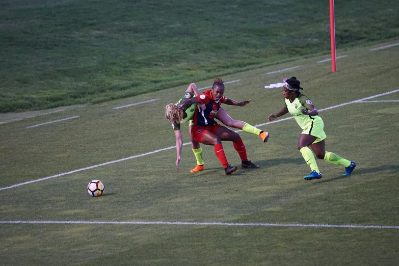 a group of young ladies playing a game of soccer