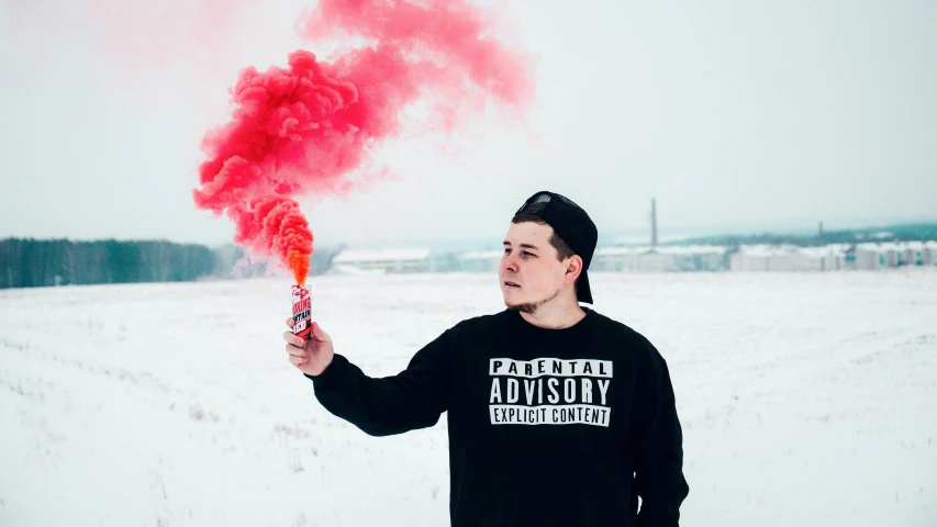 a man in black shirt holding red and pink smoke cannon