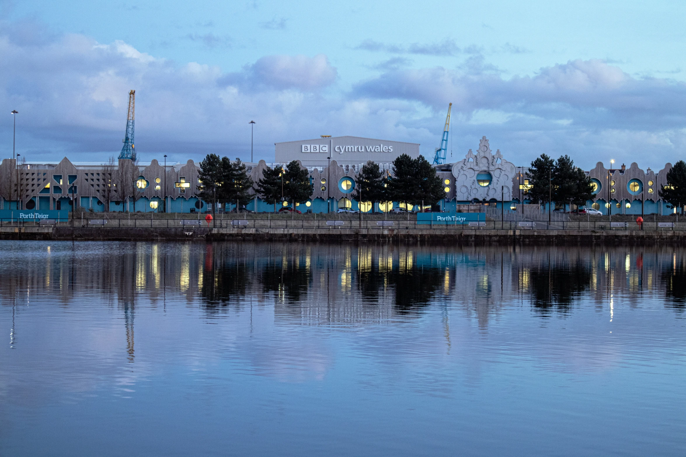 a city at night reflected in the still water of a river