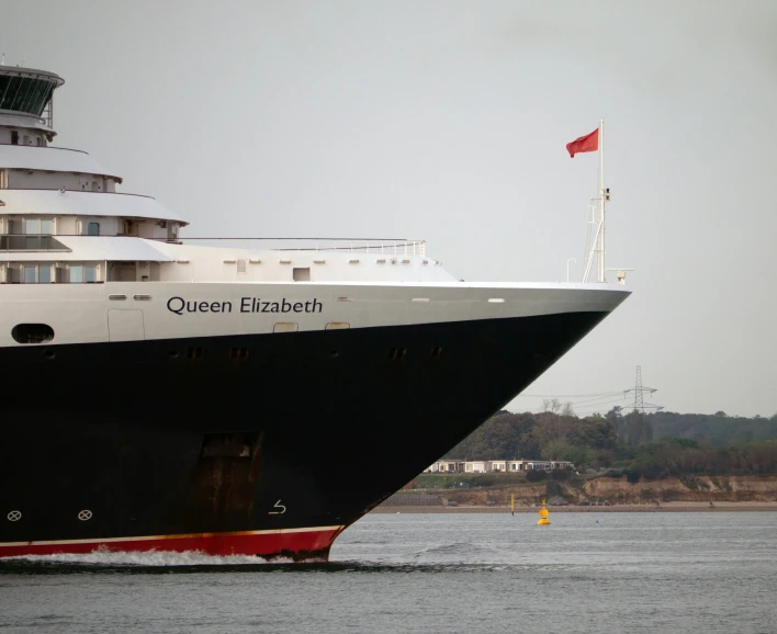 a large cruise ship in a harbor with a red and white flag