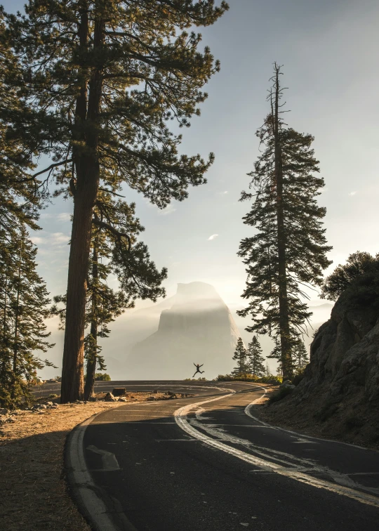 a curved road leading to a mountain on either side