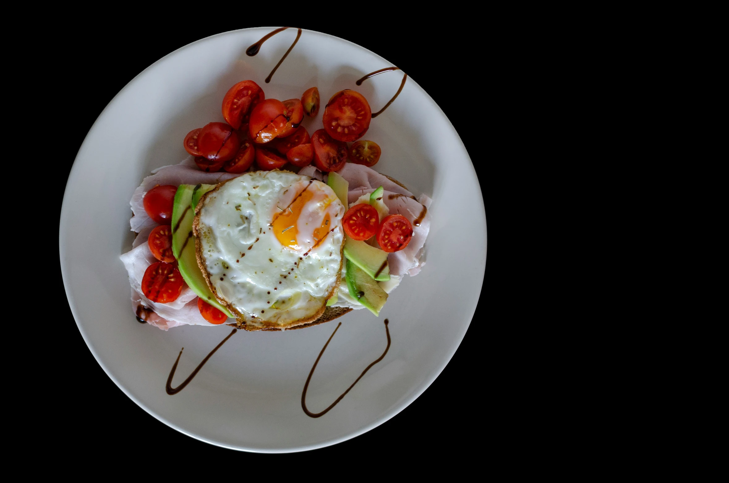 a white plate topped with fried eggs and tomatoes