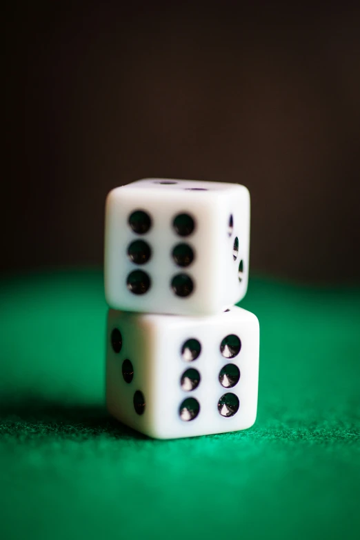 two white dices sitting on a green table