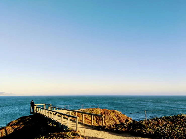 a wooden path crosses over a vast ocean