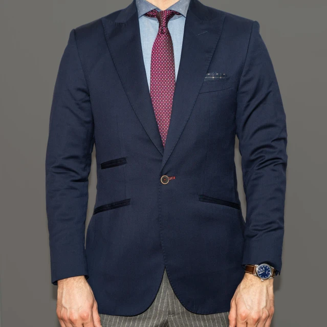 a person in a blue suit standing with their hands in his pockets