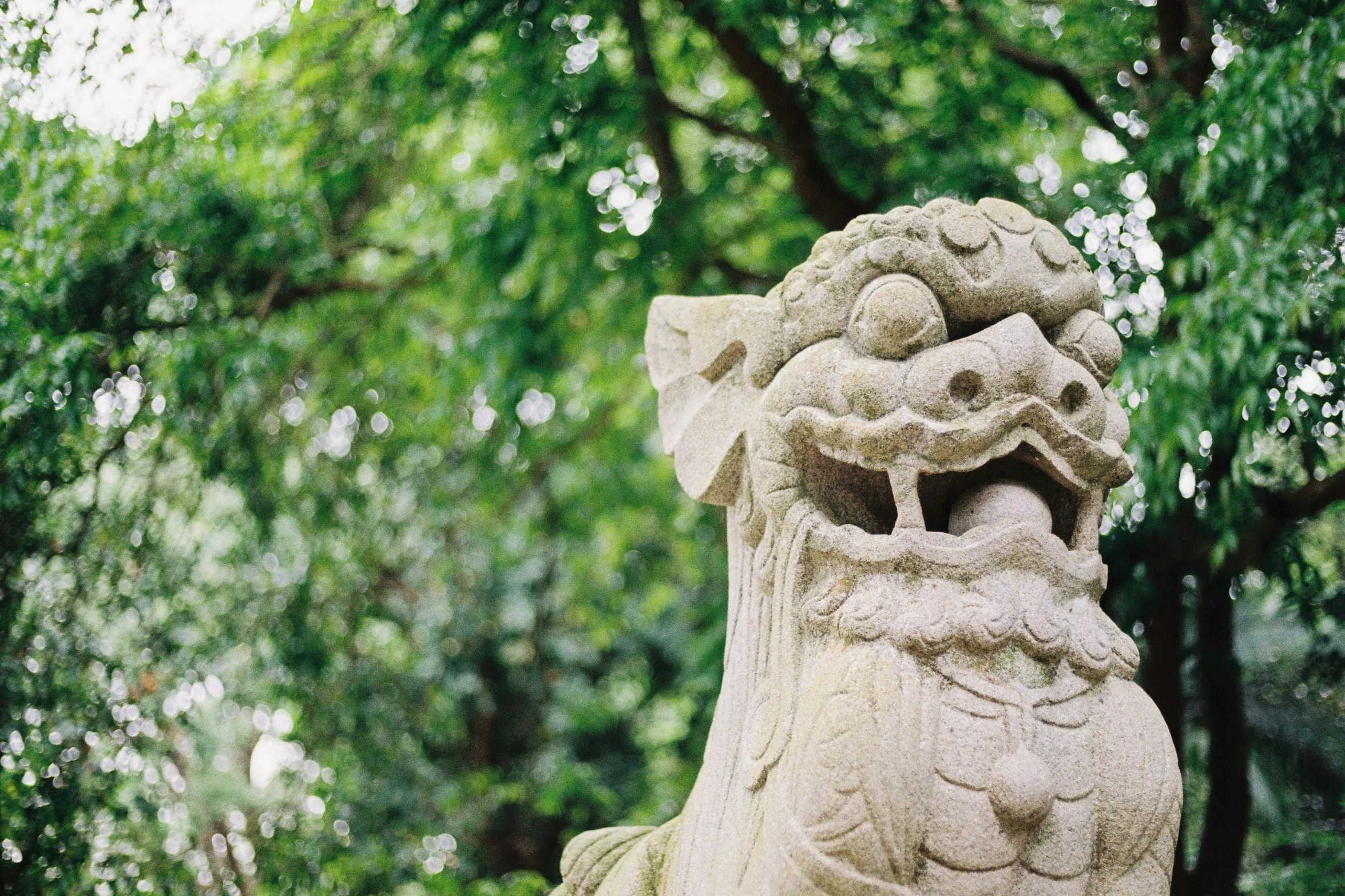 an oriental stone statue in the middle of a forest