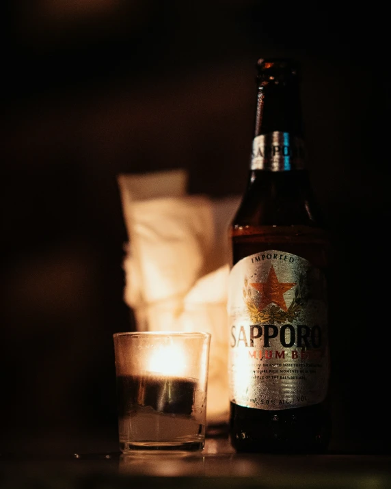 a beer bottle with smoke in the background next to an alcoholic beverage