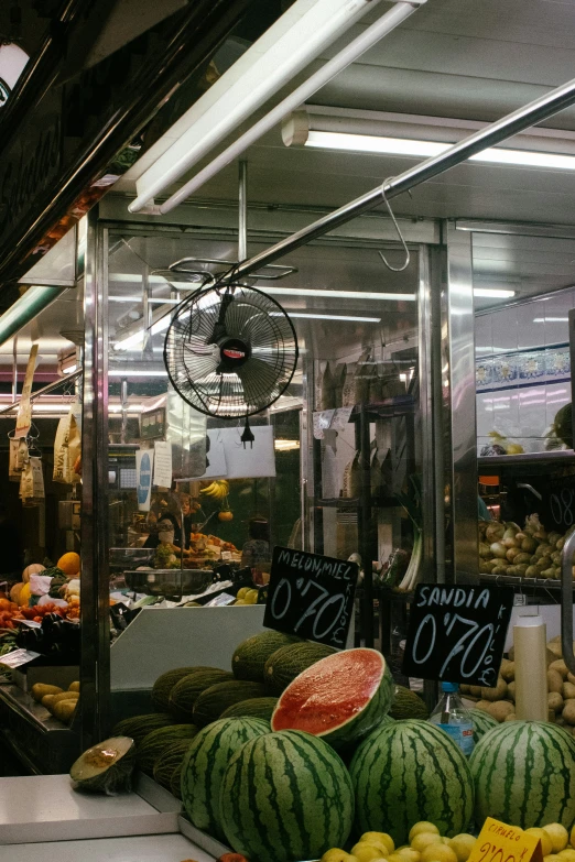 watermelon and other produce sit on display in a shop