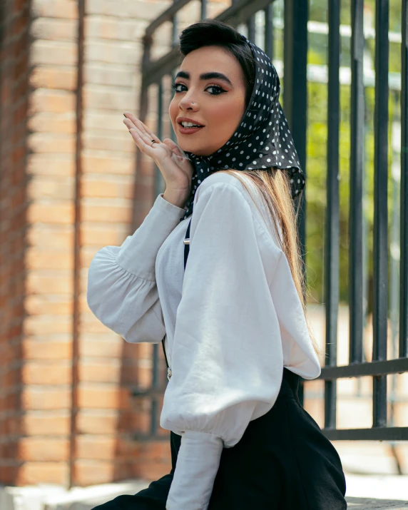 an asian woman sitting on the ground wearing a white blouse