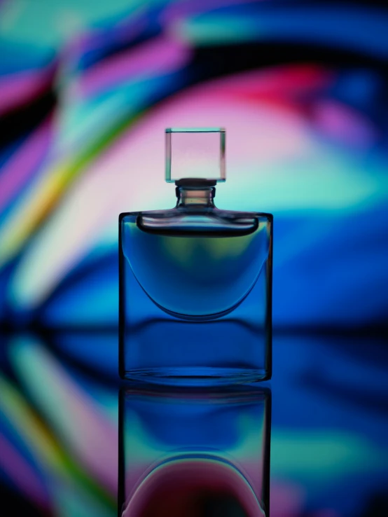 a blue perfume bottle with a multi colored swirl