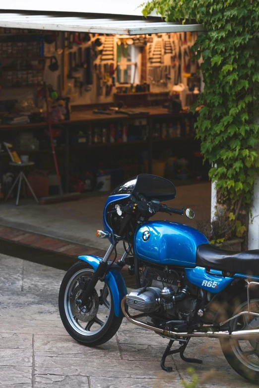 a blue motorcycle parked outside of a warehouse