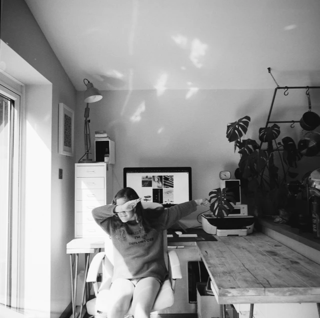 a person sitting at a table in an office space with a computer