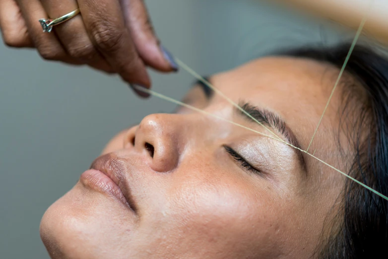 woman with straight needles being applied to her face