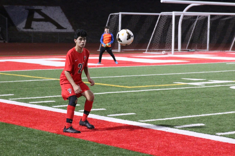 a boy on the soccer field holding the ball