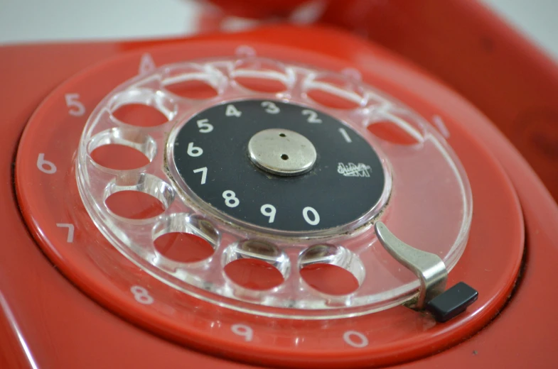 an old style red phone that is sitting on a table