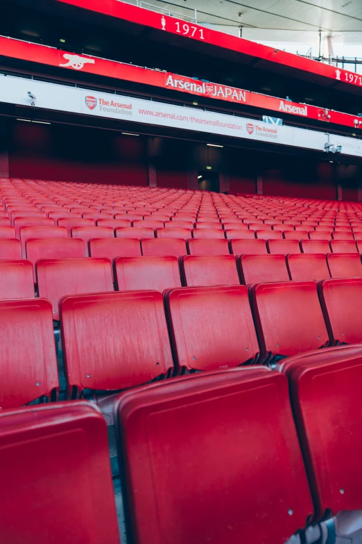 empty red stadium seats in a large empty arena