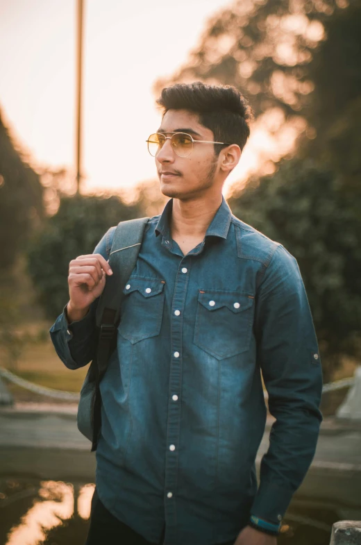 an indian man in a denim shirt and sunglasses