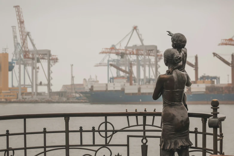 the woman statue is by the large body of water