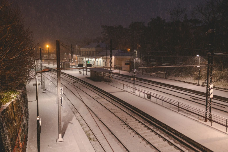 a train yard in the snow at night