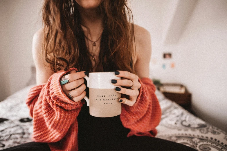 a woman holding a coffee cup in her hands