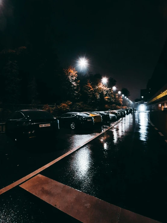 an empty street that is raining and parked cars