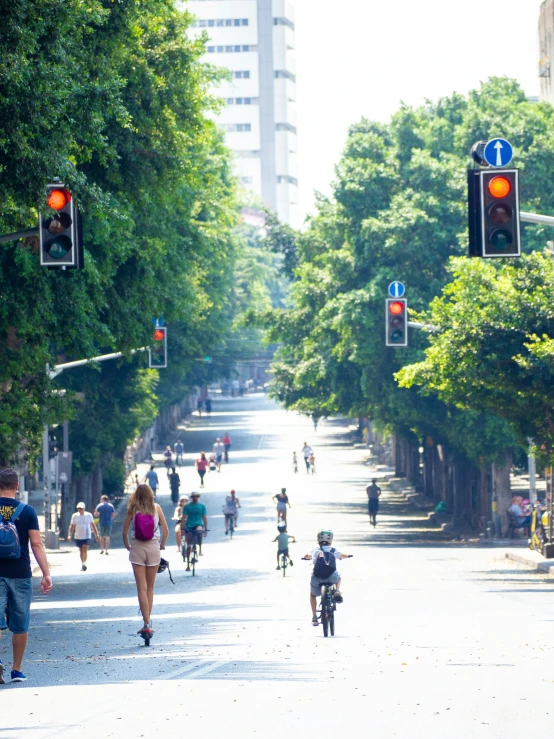 people are walking, biking, and walking through an open city street