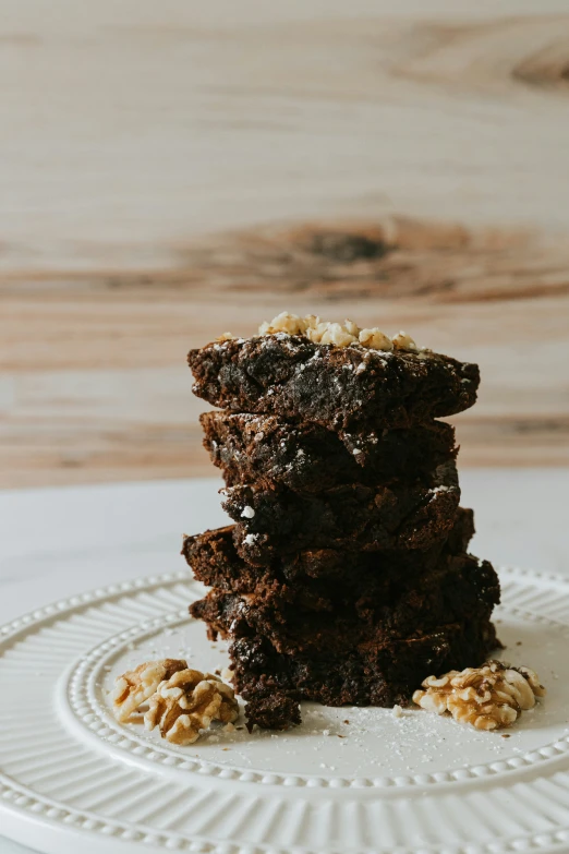 stack of brownies sitting on top of a white plate