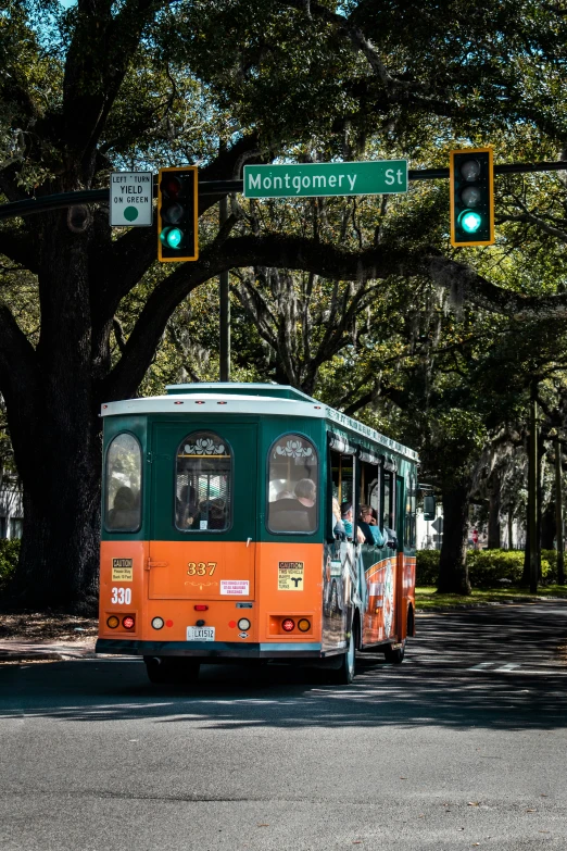 a trolley car that is pulling into the street with trees around it