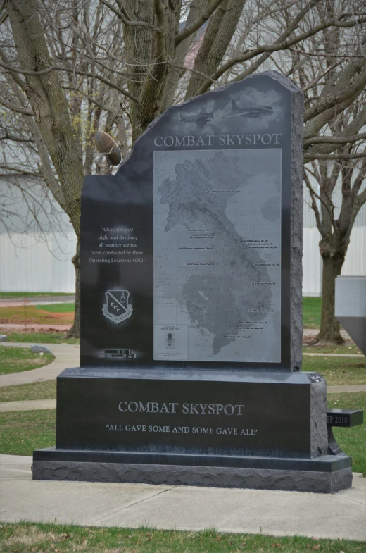 a memorial monument located on a lawn with trees in the background