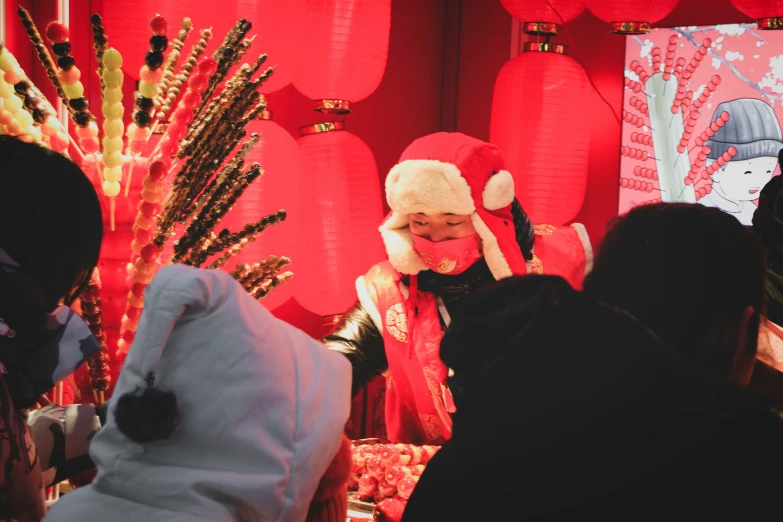 a woman standing in front of red decorated decorations