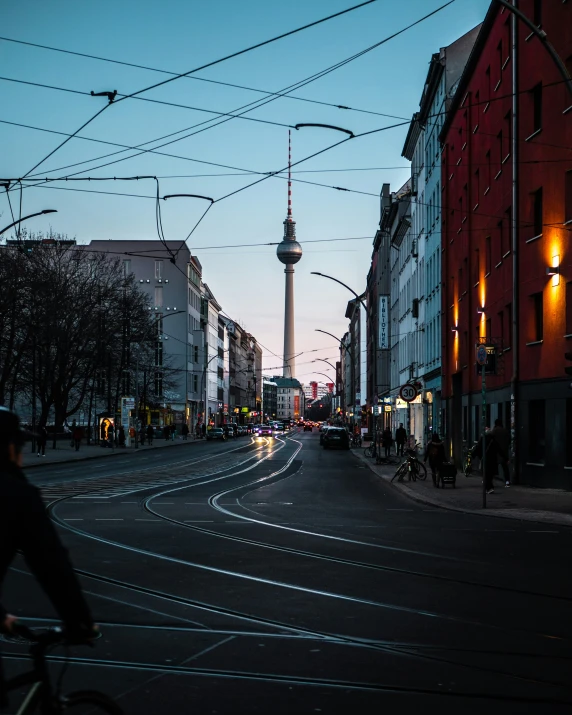 a person on a bicycle traveling down a road next to tall buildings