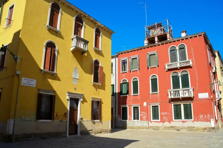 a row of multicolored buildings with red, orange, and yellow balconies