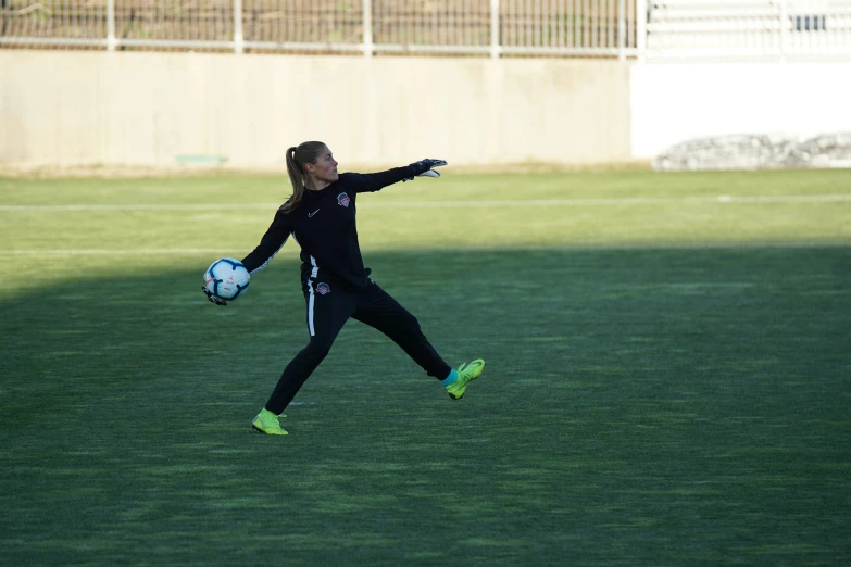 a girl on a soccer field catching the ball