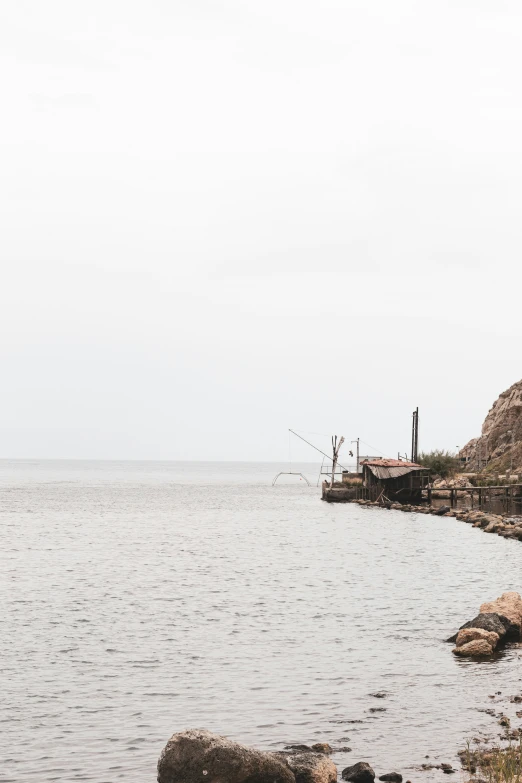 an old boat sits on the edge of a small body of water