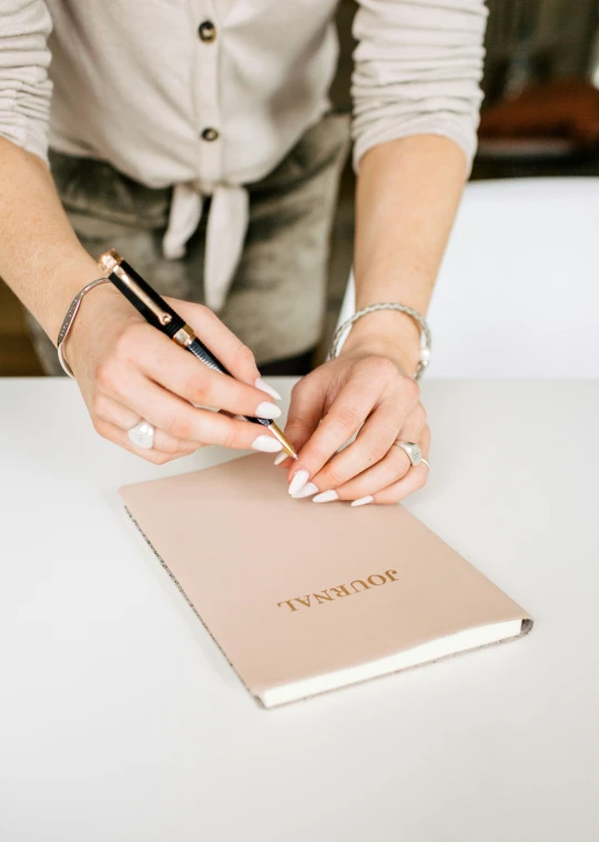 a woman is holding onto an open journal