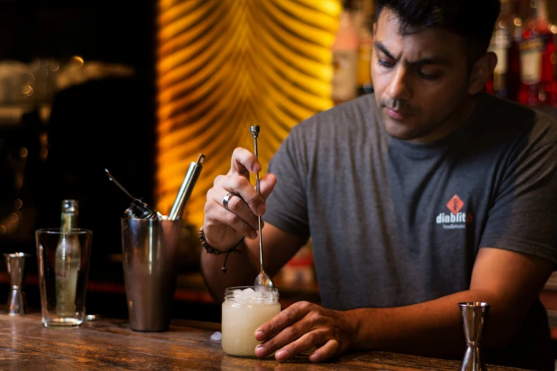 a man is at a bar holding an ice cream shaker