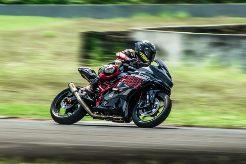 motorcycle rider on roadway near grassy area with roadway