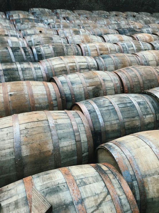 many wooden barrels stacked up near each other