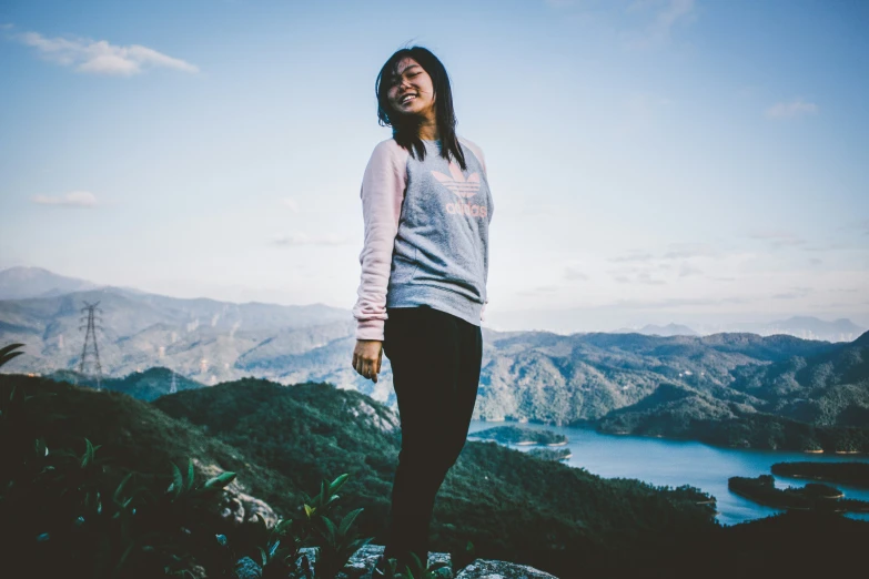 a woman wearing legging standing on top of a rock