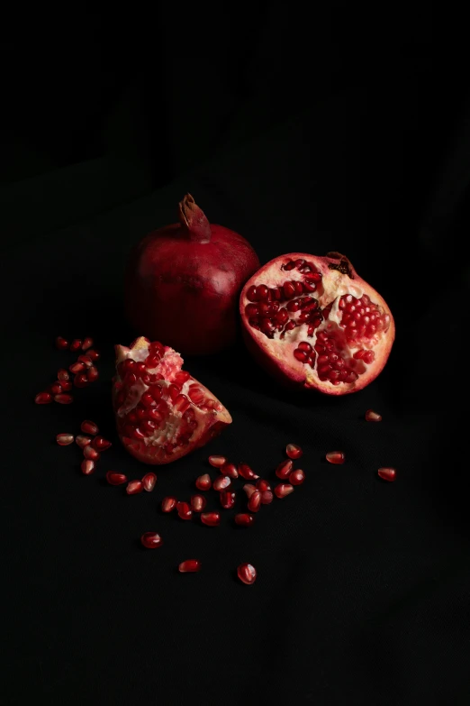 pomegranates and seed litter on a black background
