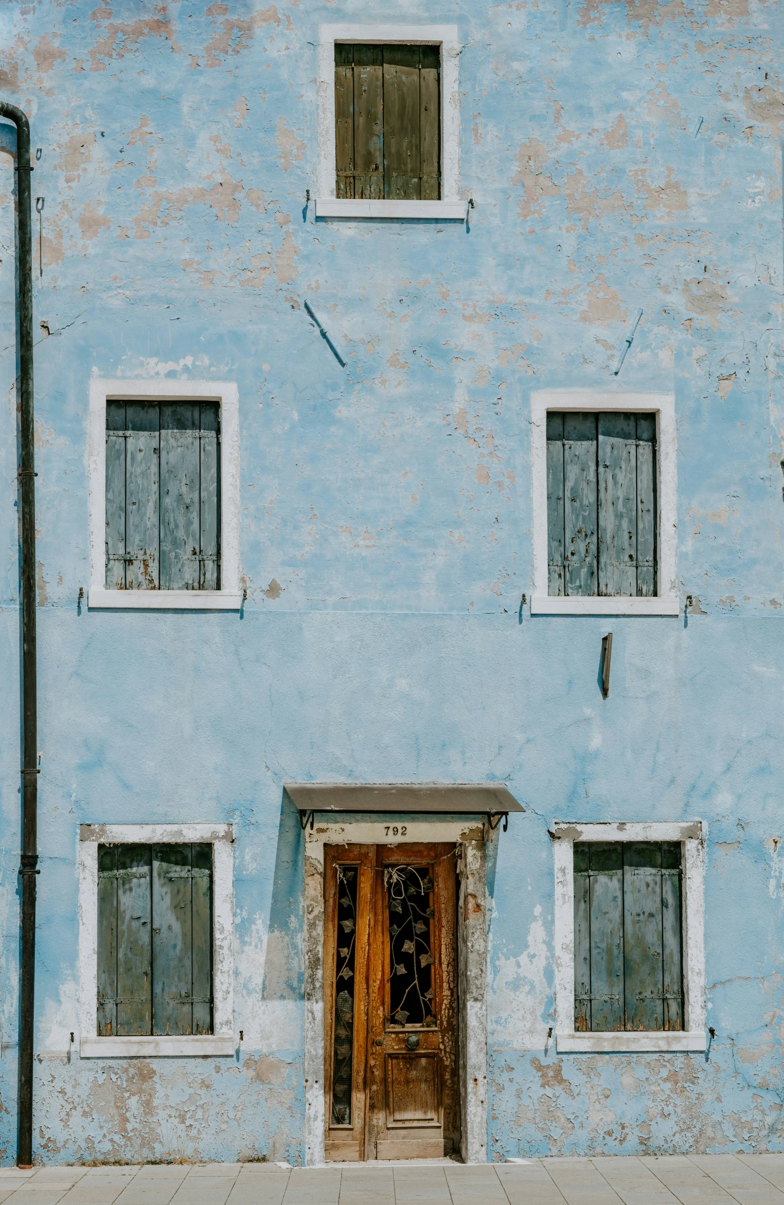 a blue building has three windows and a door