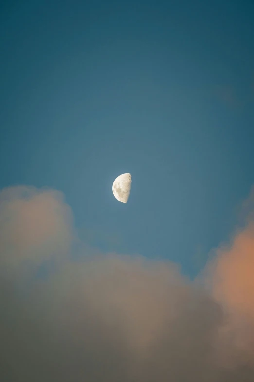 the moon shining against the blue sky is very dark