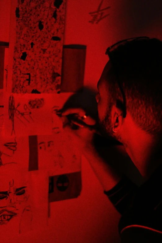 a man with his arm resting on his head in front of a dark background